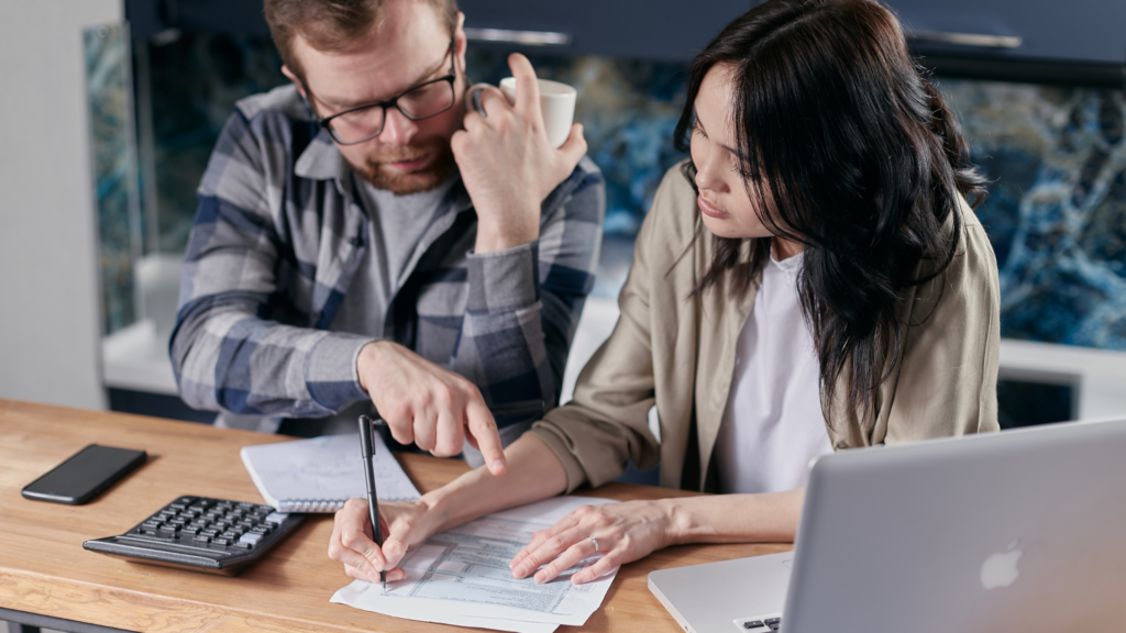 Optimistic individual or couple reviewing mortgage paperwork, symbolizing the possibility of getting a mortgage even after an IVA in the UK.