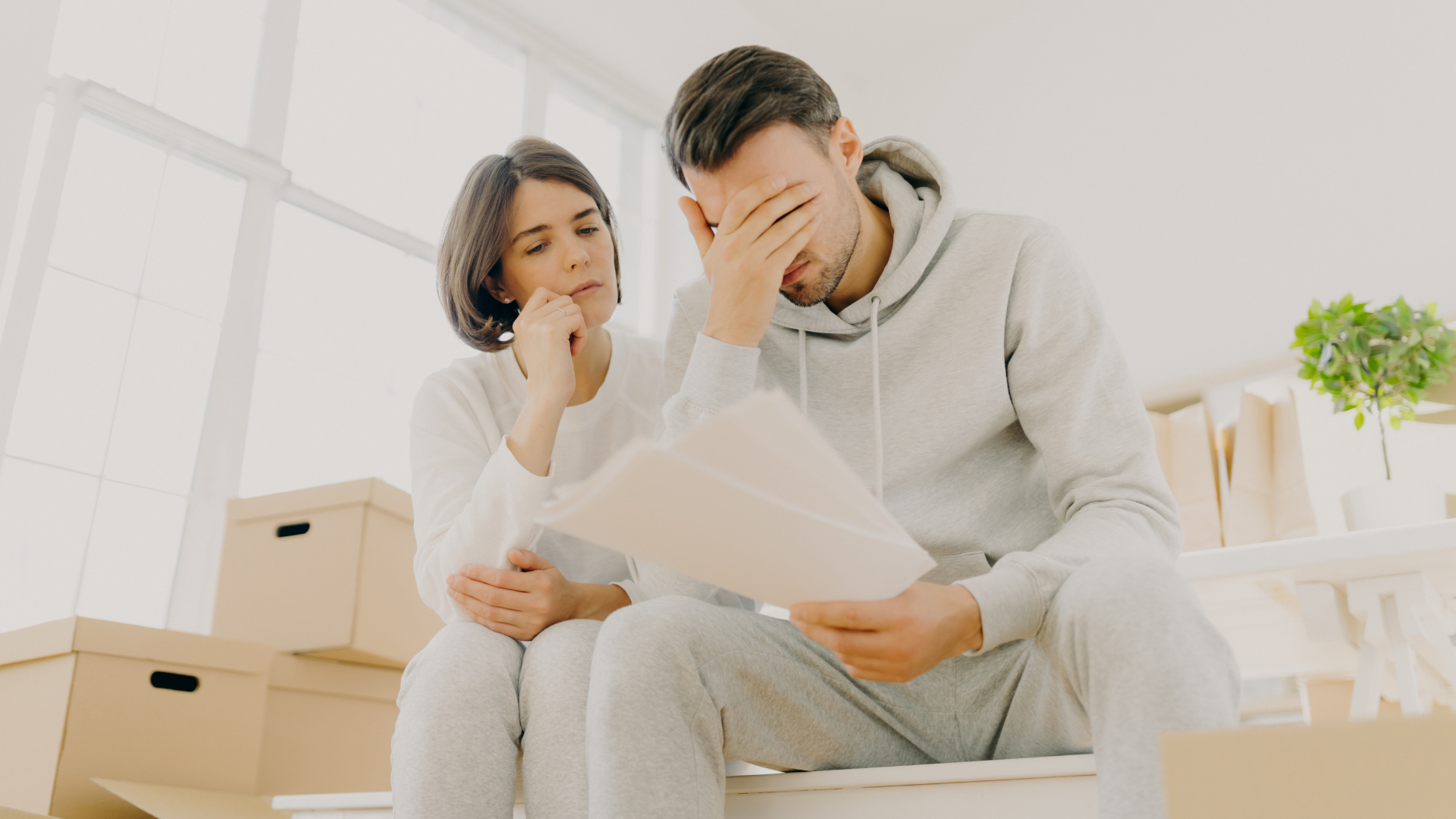 Individual or couple reviewing documents with a contemplative expression, symbolising reconsideration after a mortgage application decline.